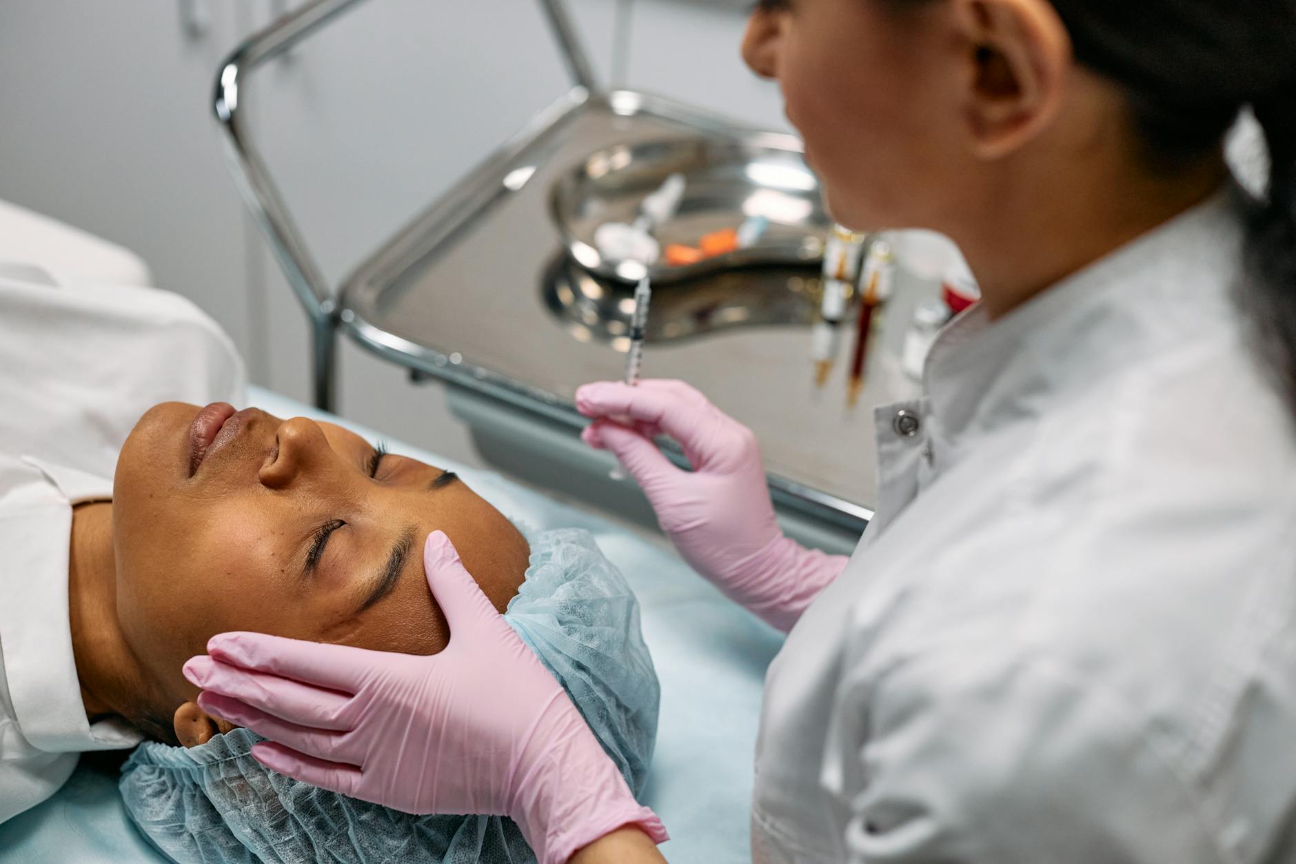Dermal filler syringe and vials on a marble surface